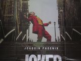 affiche représentant un homme en costume rouge en train de monter un escalier à grands bonds