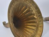 an antique brass phonom with a wooden handle on a white background