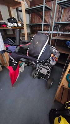 une poussette au milieu d'une pièce remplie de vêtements