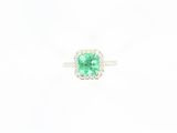 an emerald and diamond ring on a white background