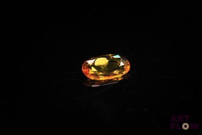 a close up of a yellow diamond on a black surface