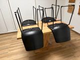 four black suitcases on a wooden table in a room