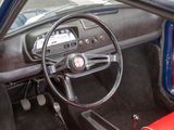 a steering wheel and dashboard of a car with a red seat