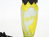a yellow and blue vase with a black cord attached to it