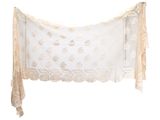 beige and white lace scarf hanging on a white wall