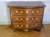 a small chest of drawers on a hard wood floor