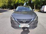 the front of a grey nissan vehicle parked on the side of the road