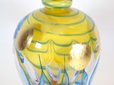 a yellow and blue glass vase on a white surface