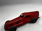 une petite voiture rouge posée sur une surface blanche