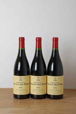 trois bouteilles de vin rouge sont posées sur une table en bois