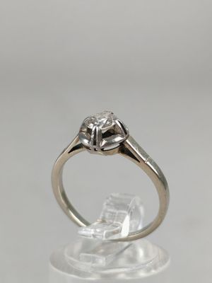 a close up of a diamond ring on a clear surface