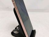 a close up of a cell phone on a stand on a white surface