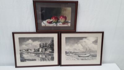 trois photos encadrées représentant des bateaux, posées sur une table blanche