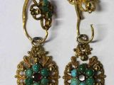 une paire de boucles d'oreilles ornées de pierres vertes et rouges
