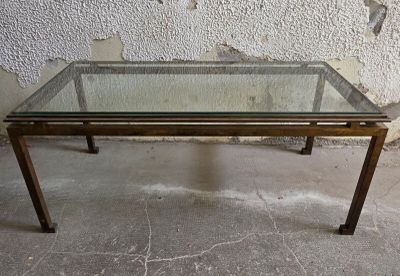 une table en verre avec un cadre en métal et un plateau en verre