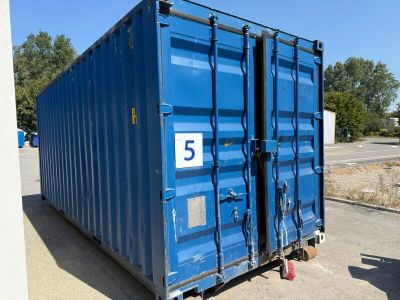 a blue container sitting in the middle of a parking lot