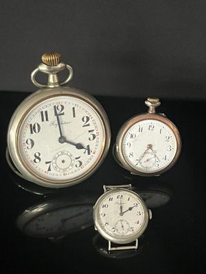 three different types of pocket watches sitting on a black surface