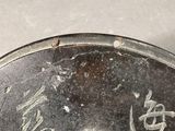 a silver plate with writing on it on a table
