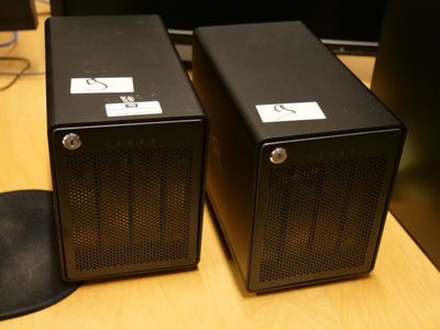deux enceintes noires posées sur une table en bois