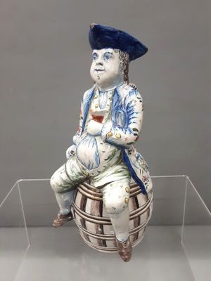 a figurine of a man sitting on top of a basket