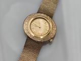 gros plan d'une montre-bracelet en or sur une surface blanche