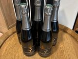 trois bouteilles de champagne posées sur un tonneau en bois