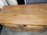 an old wooden cabinet with two doors and a drawer