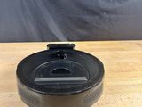 a close up of a black lid on a wooden table