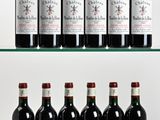 several bottles of wine are lined up on a glass shelf