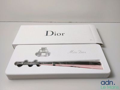 une boîte contenant un fer à lisser rose et noir