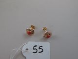 two pairs of red and gold earrings with a price tag