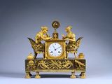 une horloge en or ornée d'anges, posée sur une table