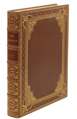 un vieux livre à la couverture brune posé sur une surface blanche