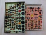 two boxes that have buttons in them on a table