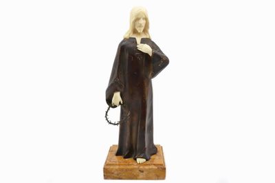 figurine représentant une femme tenant un chapelet, posée sur un socle en bois