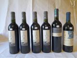 six bottles of wine are lined up in a row on a table