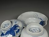 three blue and white bowls and saucers sitting on a table