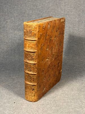 an old book sitting on top of a table next to a gray background