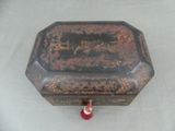 une boîte noire et rouge posée sur une table blanche