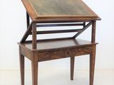 un petit bureau en bois surmonté d'un plateau en verre
