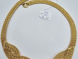 un collier en or avec un motif tressé sur fond blanc