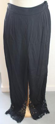 un mannequin portant un pantalon noir orné de lacets