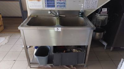 a sink and a trash can in the kitchen