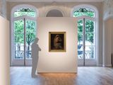 a sculpture in the middle of a room with a painting on the wall