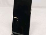 a black cell phone sitting on a stand on a table