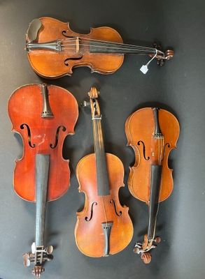 three old violin ' s hanging on a wall in a room
