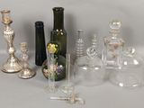 de nombreux types de bouteilles et de vases en verre sur la table