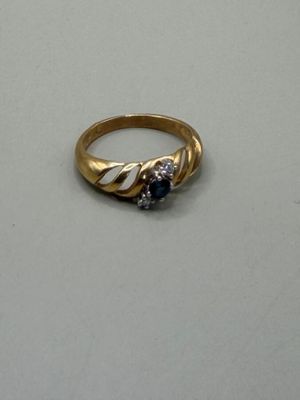 une bague en or sertie d'une pierre bleue et d'un diamant