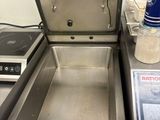 a metal pan sitting on top of a counter next to a digital scale
