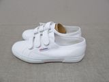 a close up of a pair of white shoes on the ground